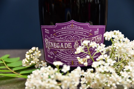 Bottle of Renegade and Longton pure elderflower sparkling wine behind a bunch of white elderflower flowers