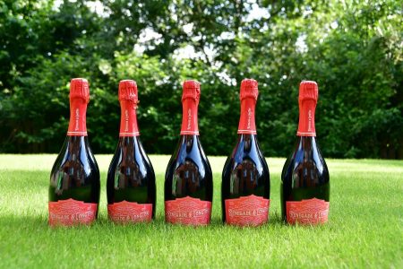 Five bottles of Renegade and Longton blush elderflower and rhubarb sparkling wine in dark wine bottles