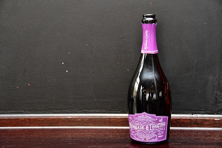 Open bottle of Renegade and Longton pure elderflower sparkling wine against a chalkboard