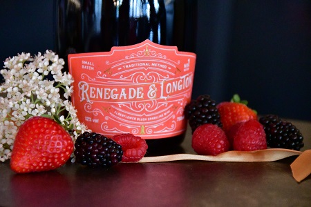 Bottle of Renegade and Longton blush elderflower and rhubarb sparkling wine with elderflowers and berries